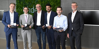 Six people smiling into the camera. Four of the prize recipients. Also, Prof. Manfred Bayer and Guido Baranowski